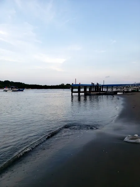 El Puerto de Mensabé - Mientras el sol se oculta por completo en el horizonte, las luces del Puerto de Mensabé empiezan a brillar, iluminando las siluetas de los barcos de pesca en el muelle.