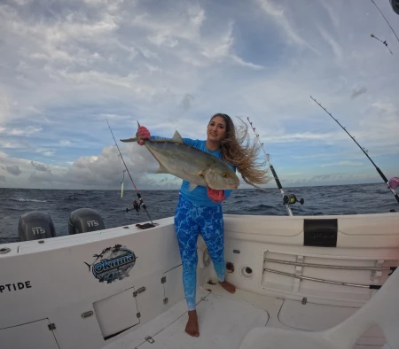 Mónica López perfeccionando su técnica de jigging en las tranquilas aguas de Puerto Morelos, con la magnificencia del atardecer como telón de fondo.