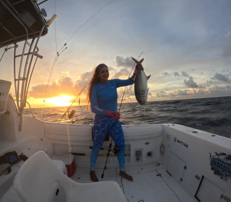 Mónica López y su Jurel: Primer Captura del Día - La experta pescadora Mónica López muestra con orgullo su primera captura del día, un robusto Jurel, testimonio de una jornada exitosa de pesca.