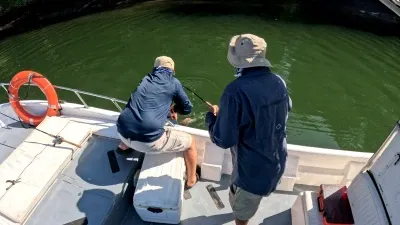 Esta foto muestra a Rainier González padre y Noble Donoso en un intenso momento de camaradería.la tensión y la emoción de la lucha que se libra bajo el agua, su atención centrada en las cañas que se doblan bajo la fuerza de una posible gran captura de Pargo Rojo.